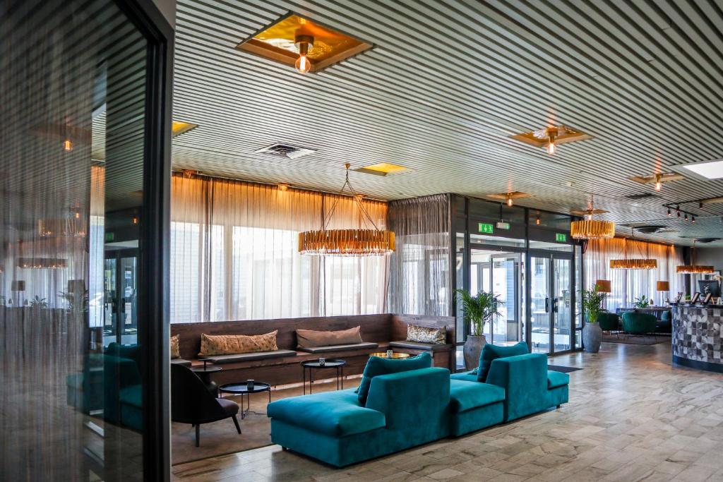 - un hall avec des chaises bleues et un canapé dans l'établissement Apple Hotel & Konferens Göteborg, à Göteborg