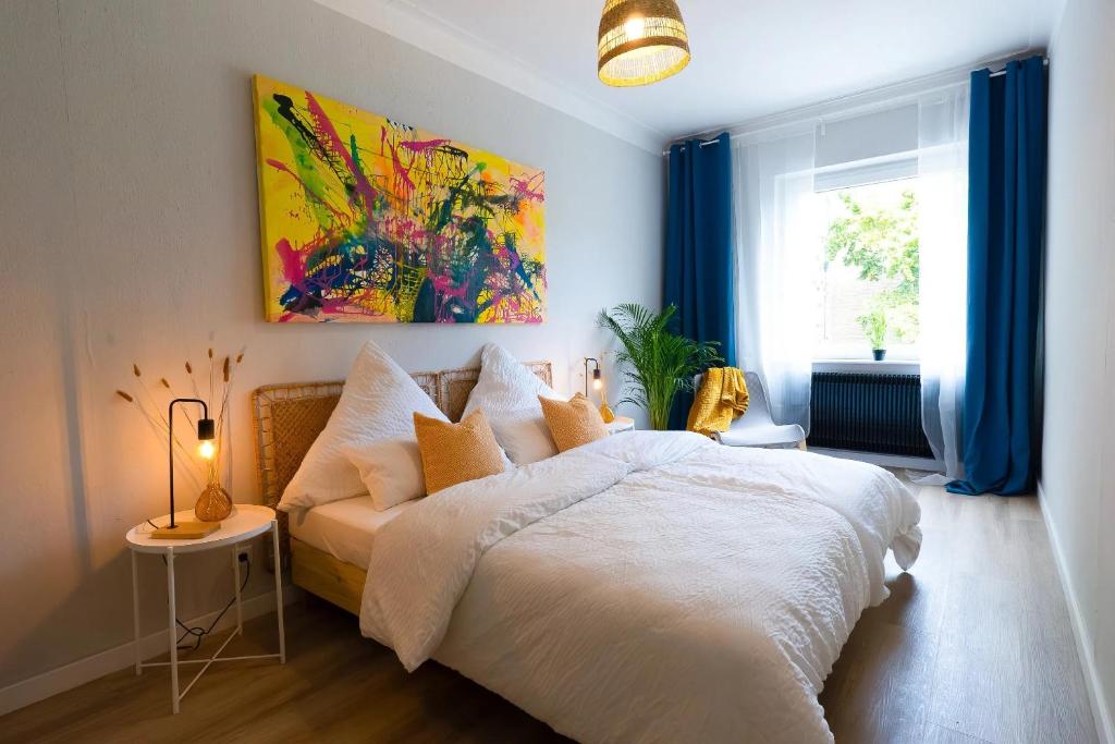 a bedroom with a white bed and a painting on the wall at BetterBeds Gelsenkirchen in Gelsenkirchen