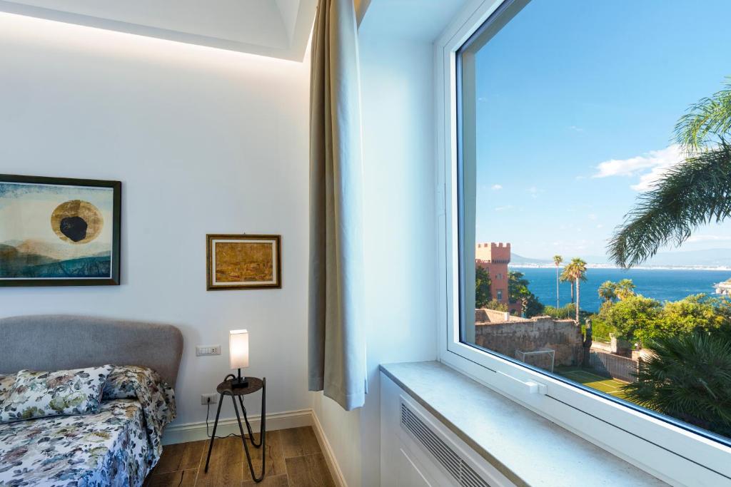 una camera con una grande finestra con vista sull'oceano di Mary’s Guest House a Vico Equense