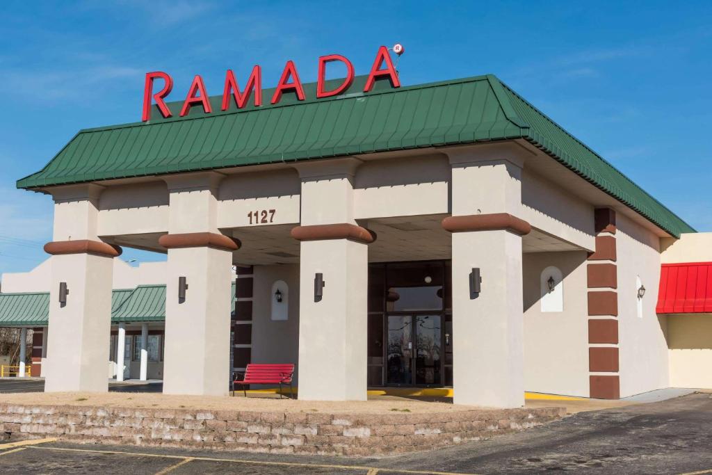 a ramada building with a red sign on it at Ramada by Wyndham Mountain Home in Mountain Home
