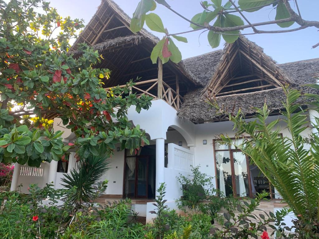 une maison blanche avec quelques plantes devant elle dans l'établissement Zi Villa Garden Room 1, à Matemwe