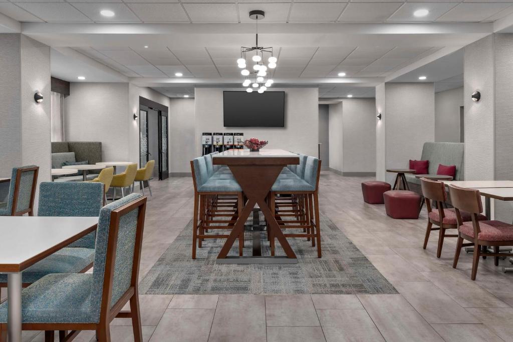 a dining room with tables and chairs and a screen at Hampton Inn Birmingham I-65/Lakeshore Drive in Birmingham