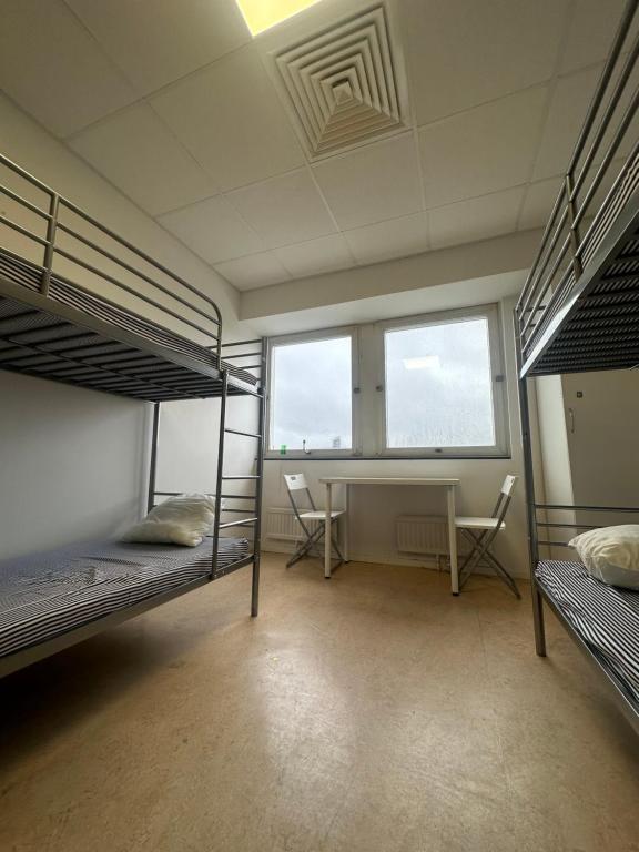 Zimmer mit 3 Etagenbetten und einem Schreibtisch in der Unterkunft Hostel by Bromma in Stockholm