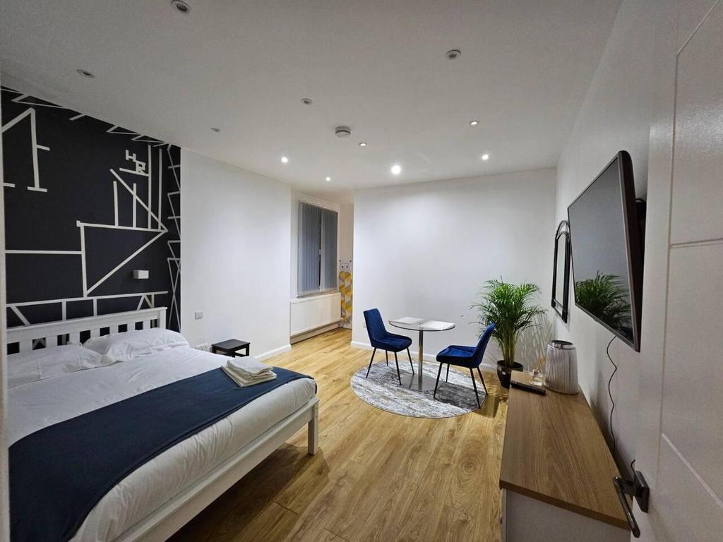 cosy 1-Bed Apartment in London Alexandra Palace في لندن: غرفة نوم بسرير وطاولة وكراسي