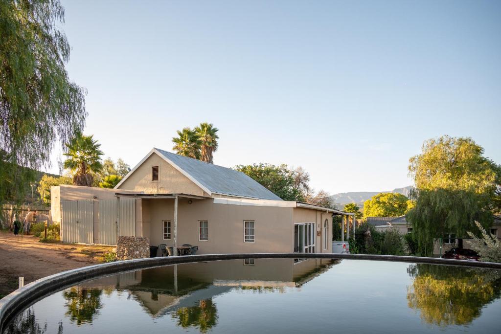 a house with a swimming pool in front of it at De Rusty Farm in De Rust