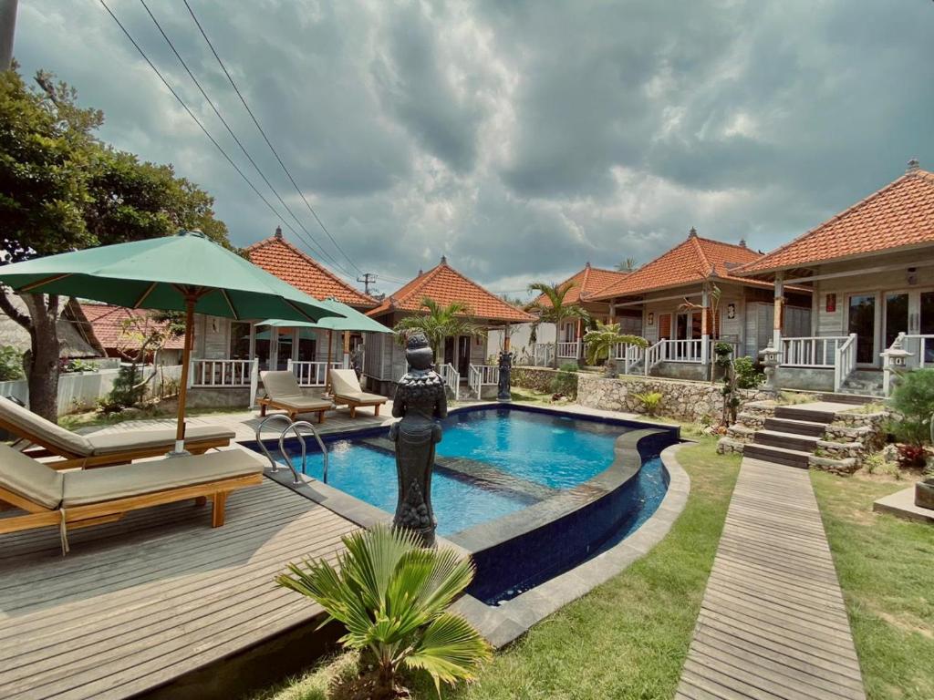 a backyard with a swimming pool and a house at Blue Sky Villa Ceningan in Nusa Lembongan