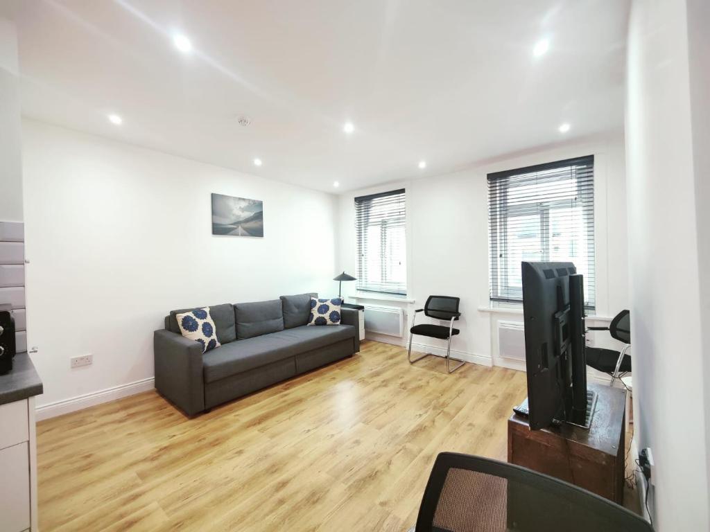 a living room with a couch and a tv at 3 Bed Flat close to Liverpool st & Brick lane in London