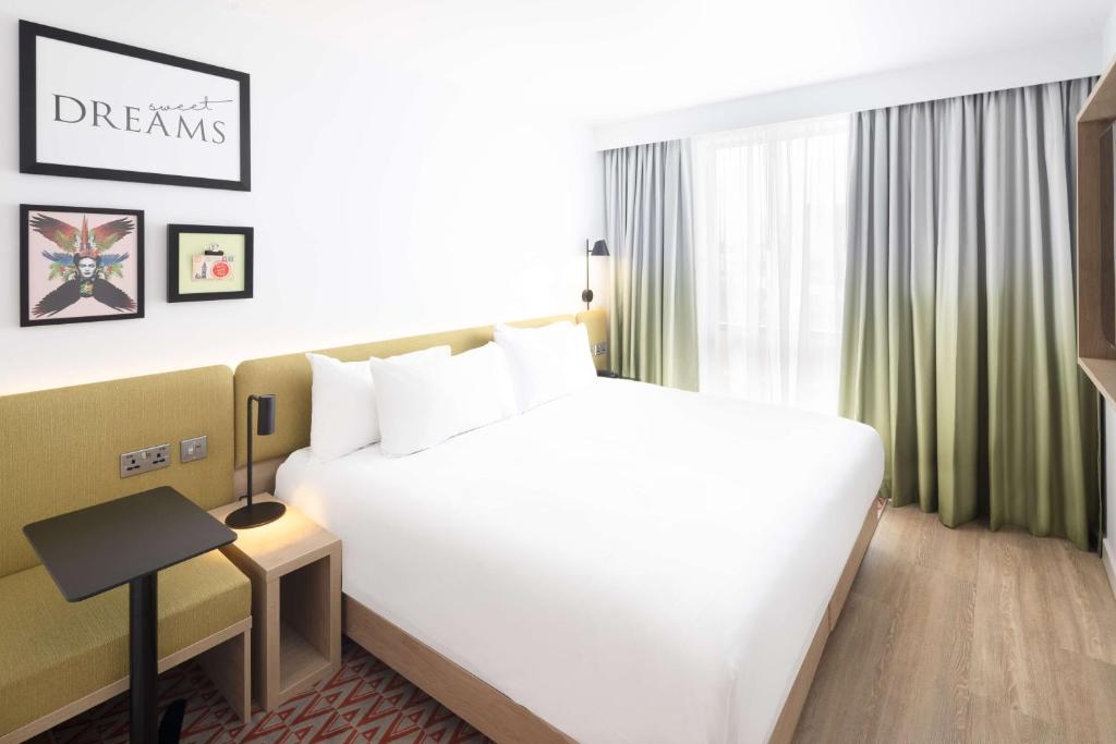 una camera d'albergo con un grande letto bianco e una finestra di Hampton By Hilton Rochdale a Rochdale