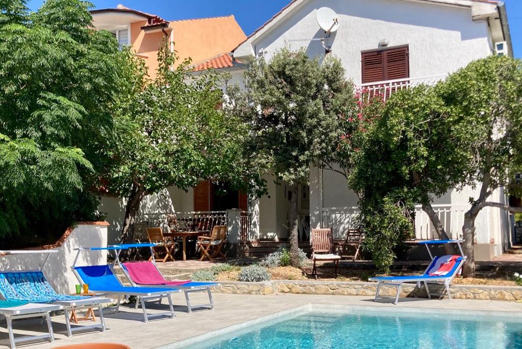 a group of chairs sitting next to a swimming pool at Villa Barbat 28 in Barbat na Rabu