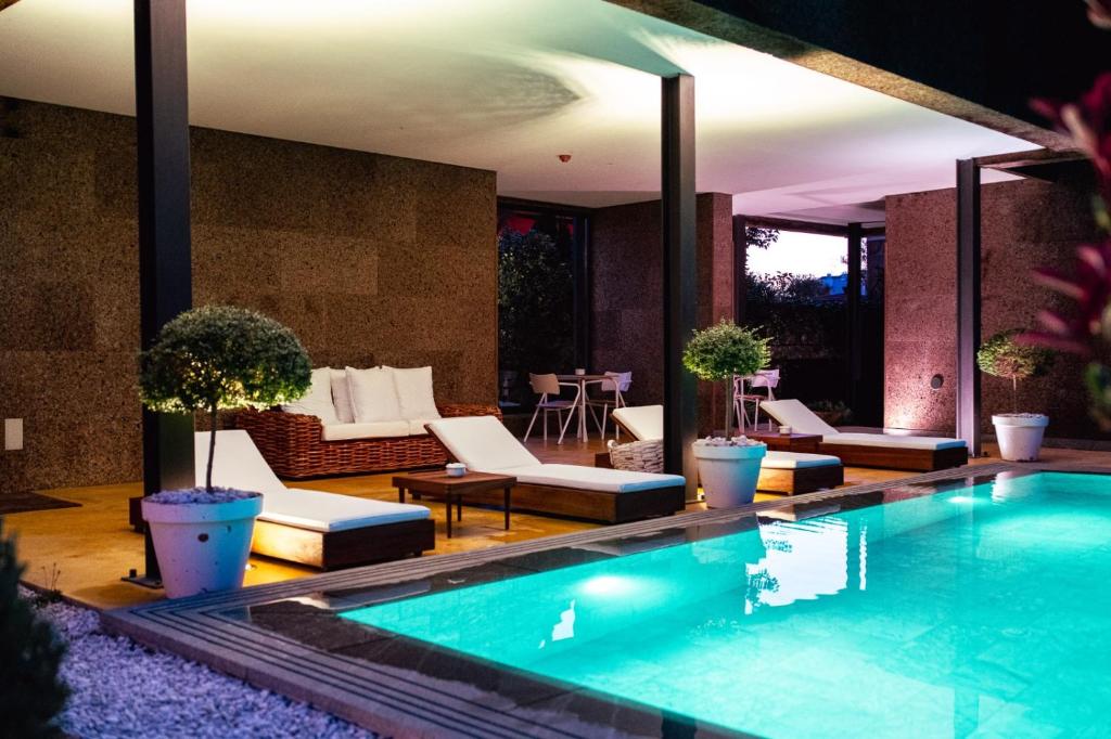 a swimming pool in a house with a patio at Casa das Mourôas in Mondim de Basto