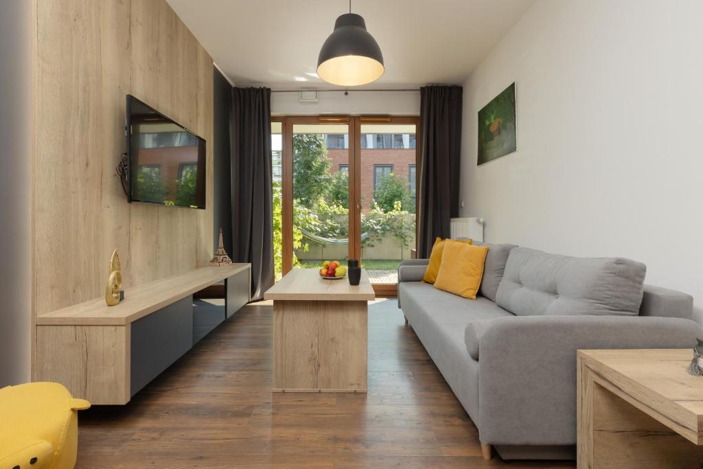 a living room with a couch and a table at Modern Apartment Home Cinema Experience by Renters in Warsaw