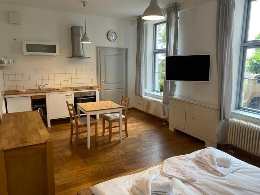 ein Wohnzimmer mit einem Tisch und eine Küche mit einem Bett in der Unterkunft Sunfe in Stralsund