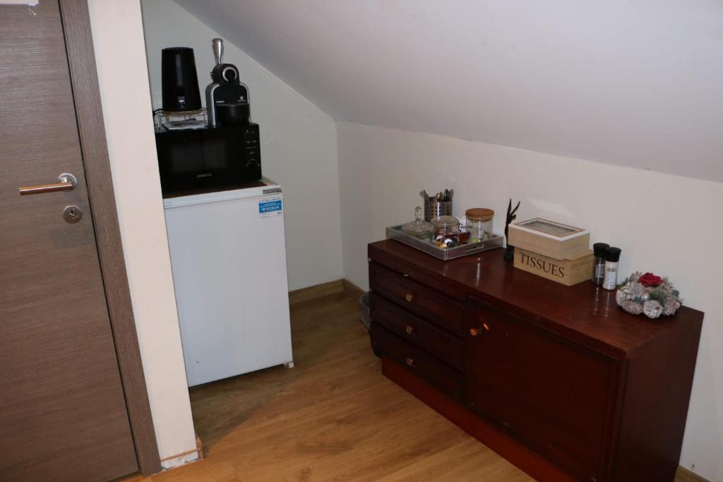 a room with a refrigerator and a dresser with a microwave at STUDIO TOUT CONFORT in Soignies