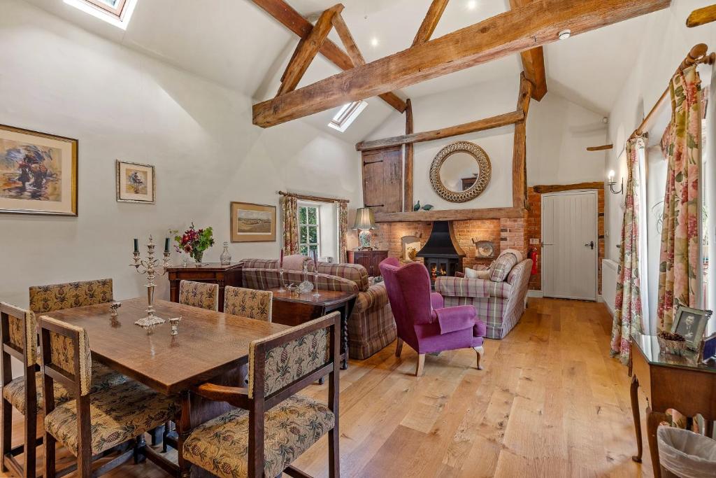 ein Wohnzimmer mit einem Tisch und Stühlen in der Unterkunft Horseshoe Cottage Farm with Hot Tub in Leicester