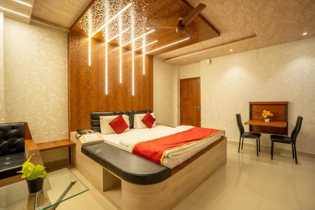 Schlafzimmer mit einem Bett, einem Schreibtisch und einem Stuhl in der Unterkunft Seasons Suites - Koramangala in Bangalore