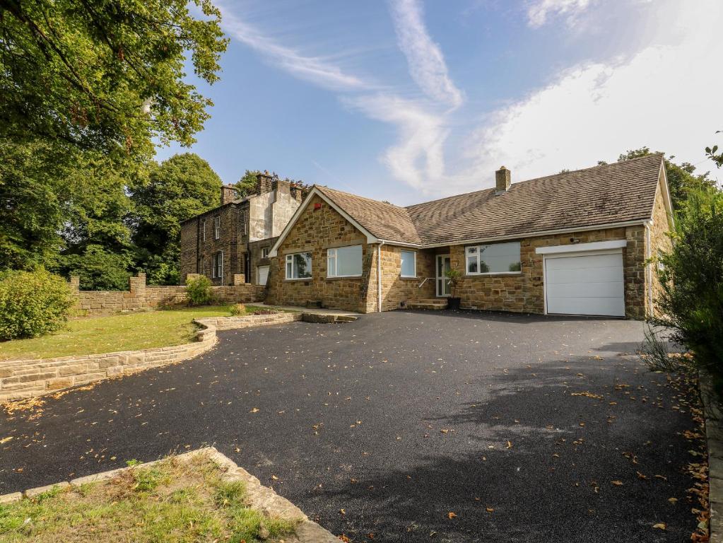 a stone house with a driveway in front of it at Copper Coin in Barnsley