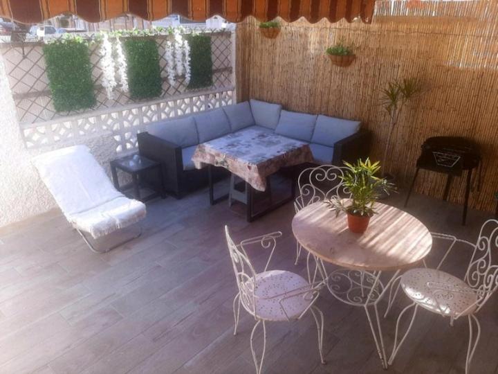 un patio con sofá, mesa y sillas en Bungalows en Santa pola, en Santa Pola