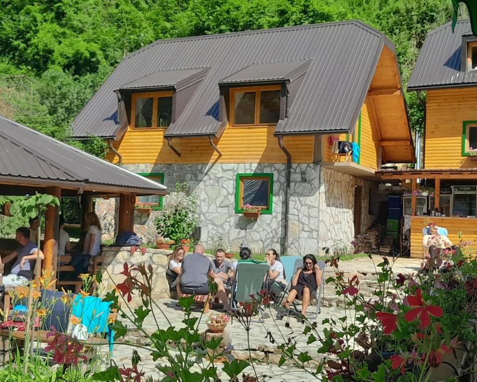 a group of people sitting in front of a house at Rafting Camp Encijan in Foča