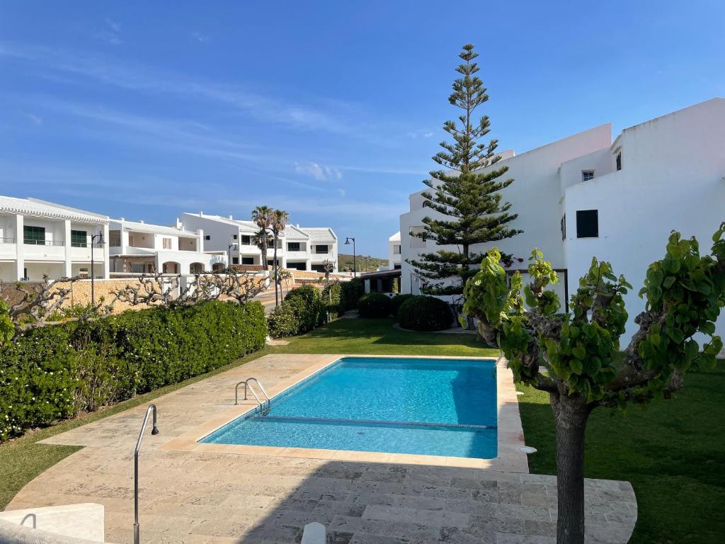 een zwembad in een tuin naast een gebouw bij SA PUNTA GRAN A2 by SOM Menorca in Fornells