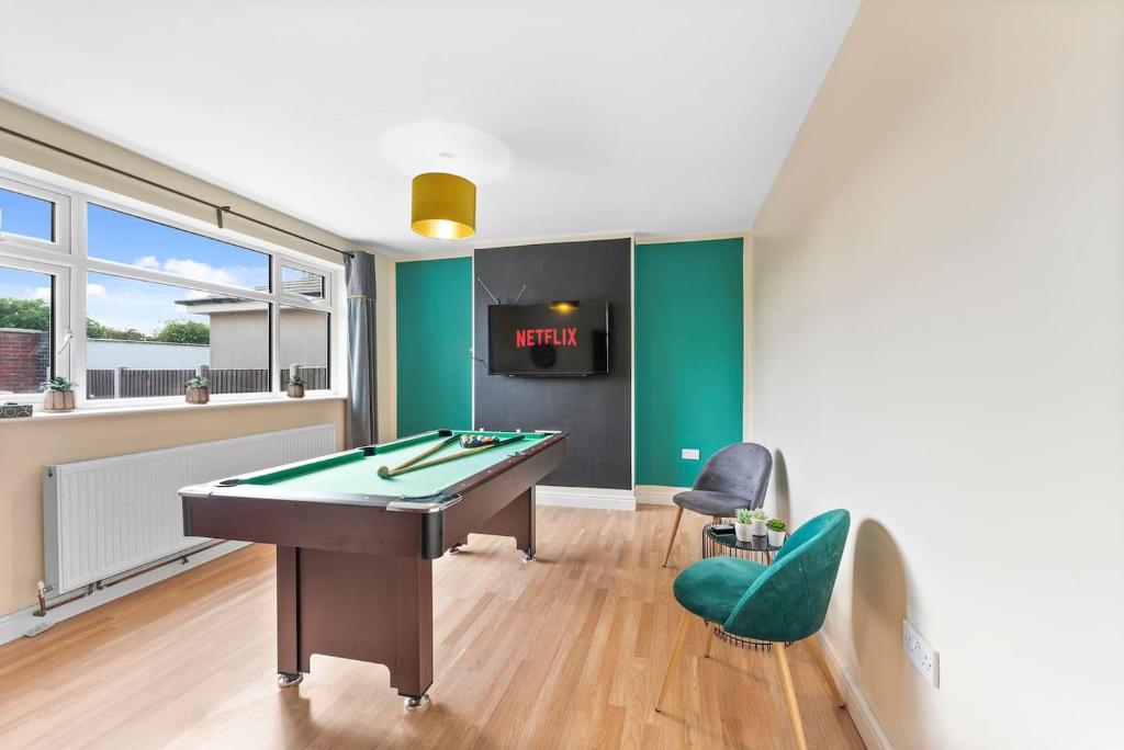 a billiard room with a pool table and two chairs at Large Peak District House - Games Room in Langley Mill