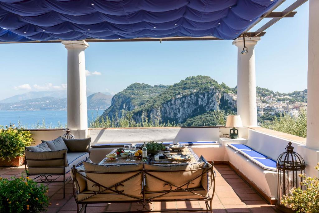 uma varanda com vista para o oceano e para as montanhas em Villa Ginestra by Elite Villas em Capri