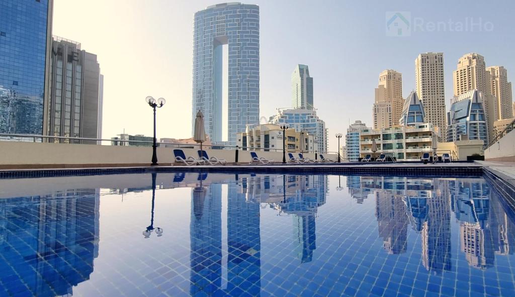 een zwembad in het midden van een stad met hoge gebouwen bij 50% OFF Summer Offert, Nice w/ Balcony & Pool View in Dubai
