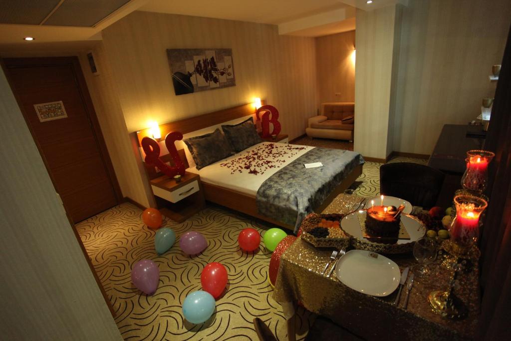 pokój hotelowy z balonami, łóżkiem i stołem w obiekcie Dies Hotel w mieście Diyarbakır