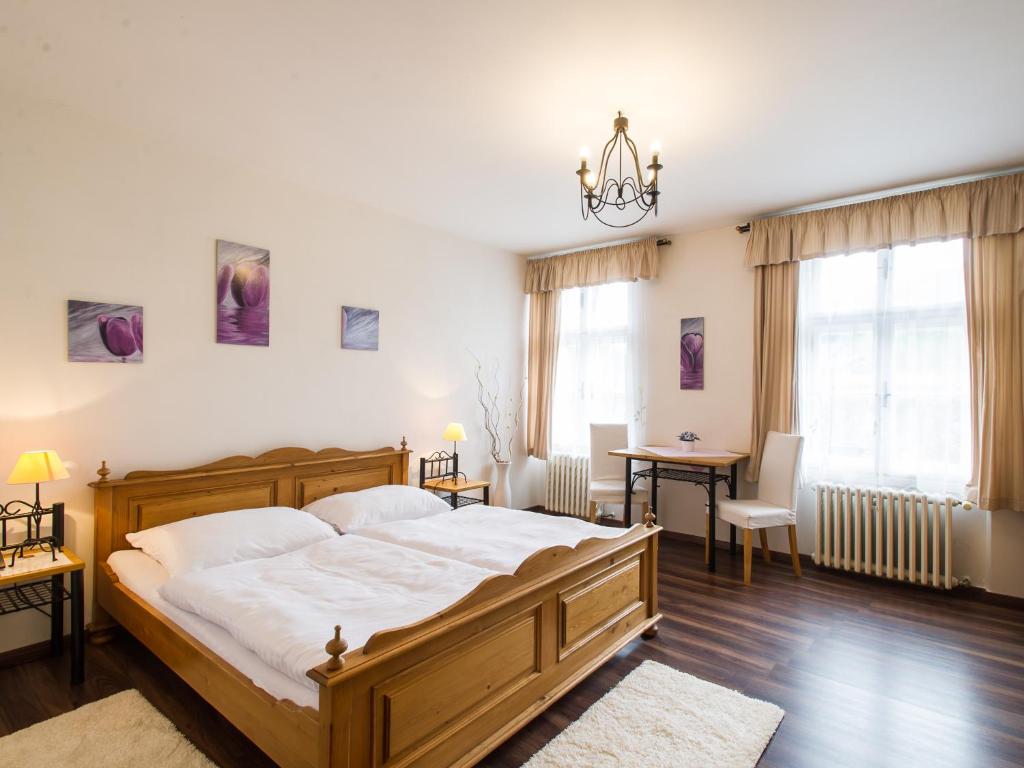 a bedroom with a large wooden bed and a table at Hotel Šumava in Vyšší Brod