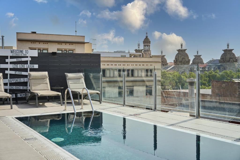 a balcony with two chairs and a swimming pool at Catalonia Born in Barcelona