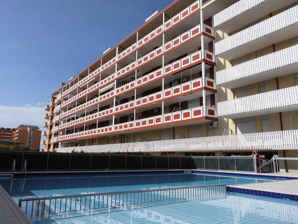 een gebouw met een zwembad voor een gebouw bij Wonderful apartment with terrace and pool in Porto Santa Margherita di Caorle