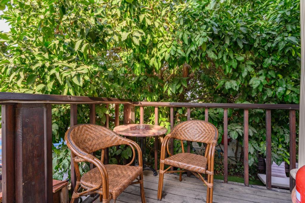 two chairs and a table on a porch with a tree at My Place in the Colony in Zikhron Ya'akov