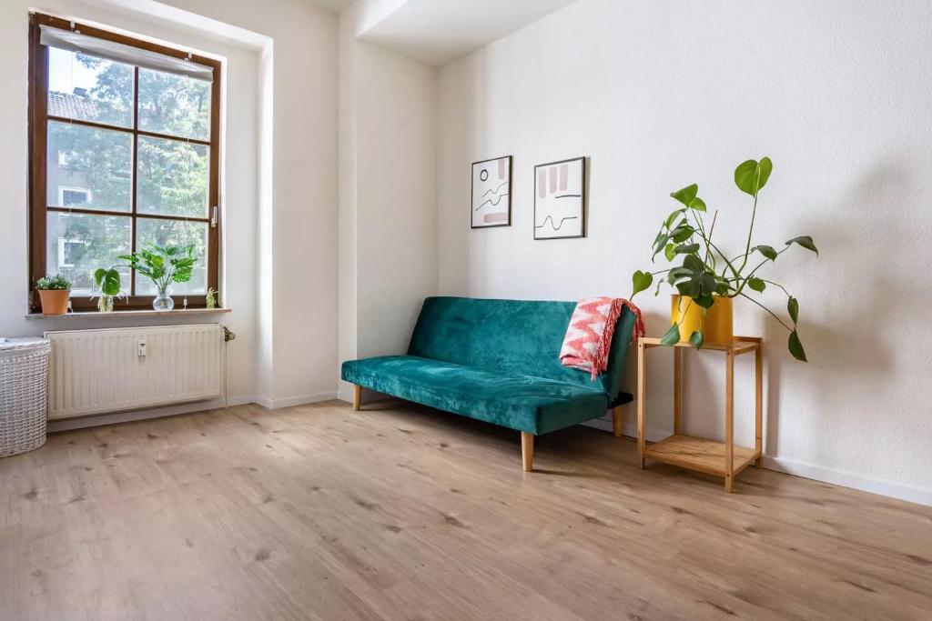 ein Wohnzimmer mit einem grünen Sofa und einem Fenster in der Unterkunft NEXT HOME - FREE Parking & WiFi - Badewanne in Duisburg