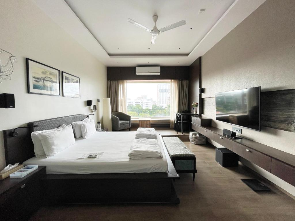 a hotel room with a bed and a large window at Central Bed & Breakfast in Kolkata