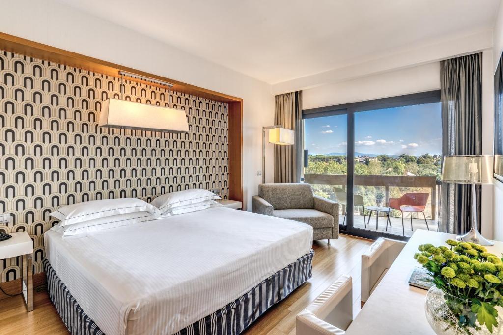 um quarto de hotel com uma cama e uma grande janela em Midas Roma Hotel - A member of Barcelo Hotel Group em Roma