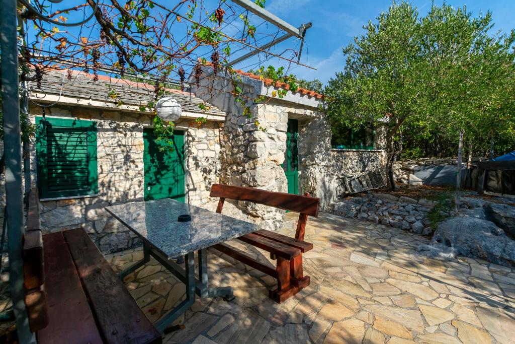 a wooden bench sitting in front of a stone building at House Stipan in Vinišće