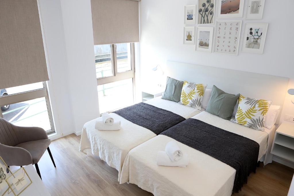 a bedroom with two beds and a chair in it at VUT PEDRO LUXURY in Padrón