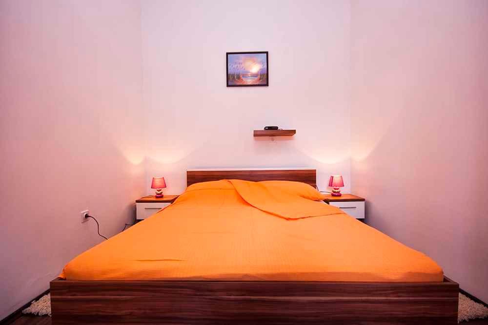 a bedroom with an orange bed with two lamps on it at Holiday home in Rakalj&#47;Istrien 8724 in Rakalj
