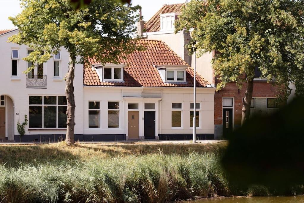 Biały dom z czerwonym dachem w obiekcie Slapen bij Zoet & Zilt w mieście Middelburg