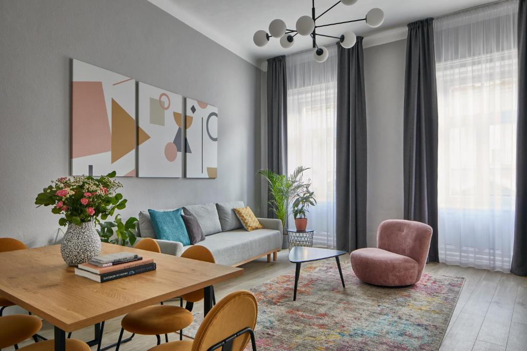 a living room with a couch and a table and chairs at Butik Life Hotel & Apartments in Budapest