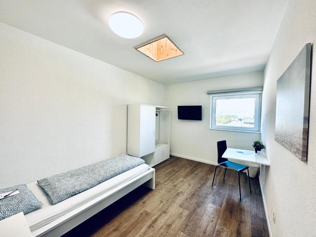 Zimmer mit einem Bett, einem Schreibtisch und einem Fenster in der Unterkunft Monteurzimmer ZIMMERzuVERMIETEN in Deitingen Industriestrasse in Deitingen