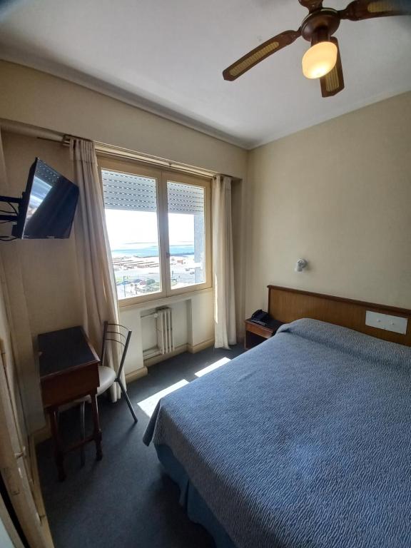 um quarto com uma cama, uma secretária e uma janela em Hotel King's em Mar del Plata