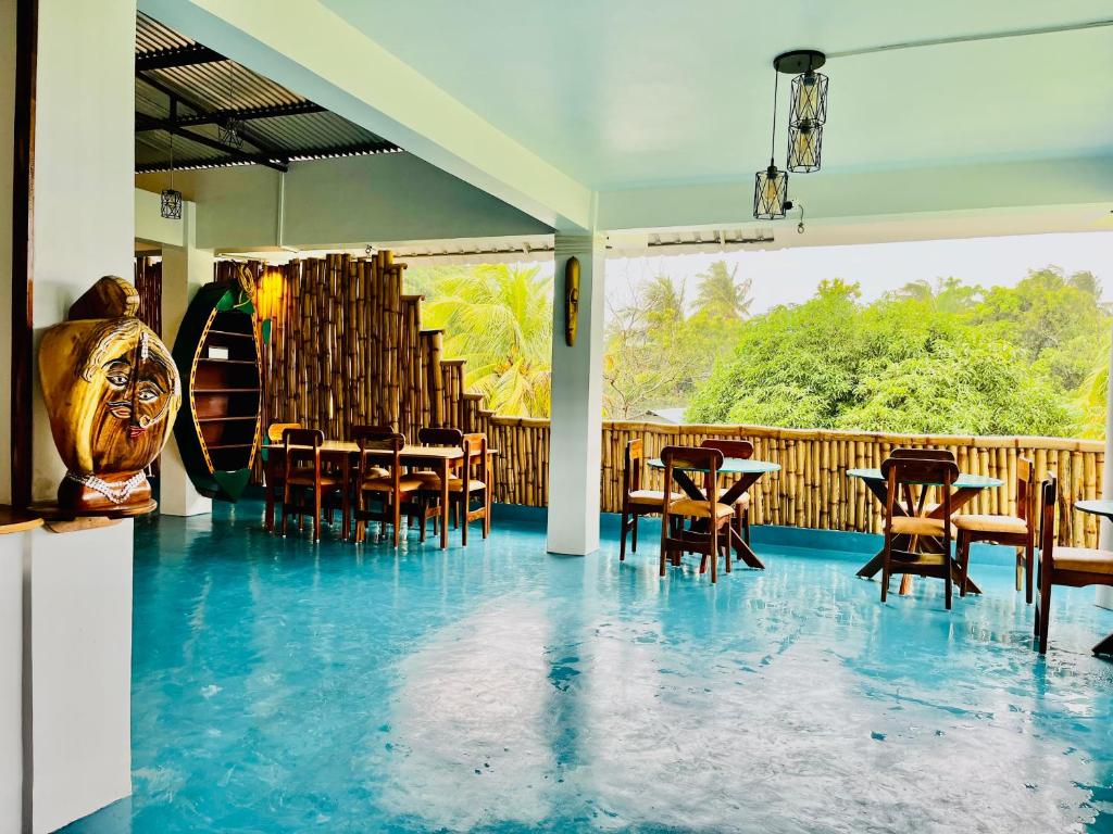 un restaurante con suelo azul, mesas y sillas en Bhūma en Havelock Island