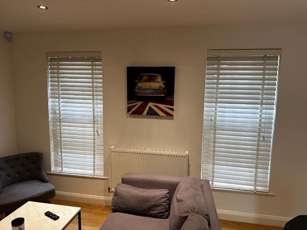 a living room with two windows and a couch at Calverley House Apartments in Bishops Stortford