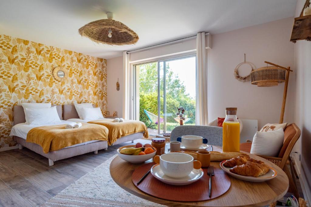 オベルネにあるLe Nichoir de la Colline - Parking & Wifiのベッド1台とテーブル(食べ物付)が備わる客室です。