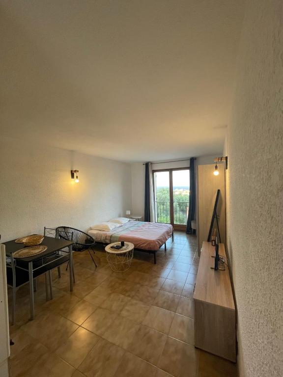 sypialnia z łóżkiem i stołem w obiekcie Appartement T1 w mieście LʼÎle-Rousse