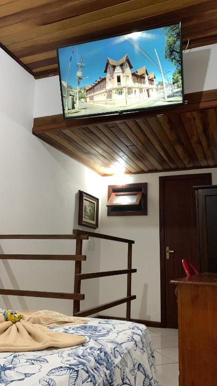 a bedroom with a bed with a tv on the ceiling at Flat lindo paraty in Paraty