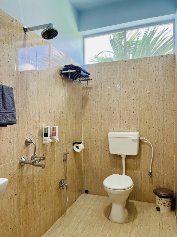 a bathroom with a toilet and a shower and a sink at Bhūma in Havelock Island
