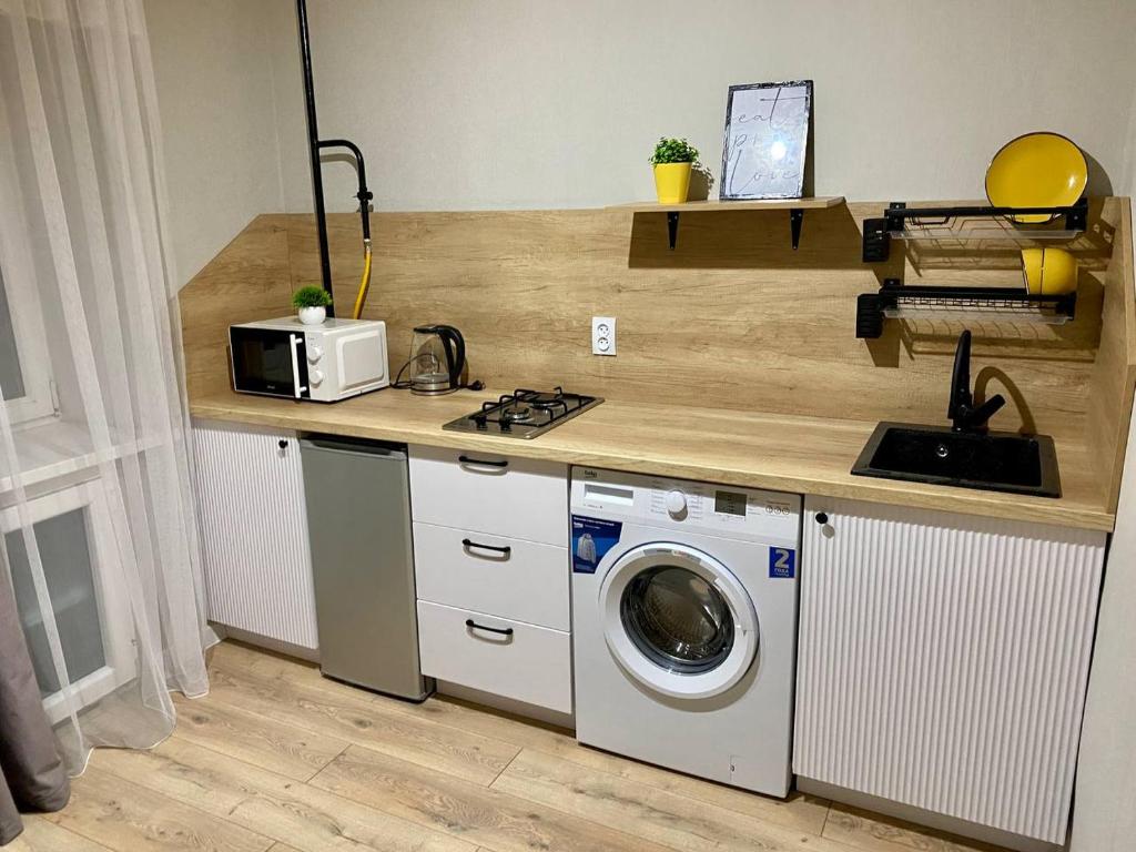 a kitchen with a sink and a washing machine at 1-комнатная квартира в районе Космос in Aktobe
