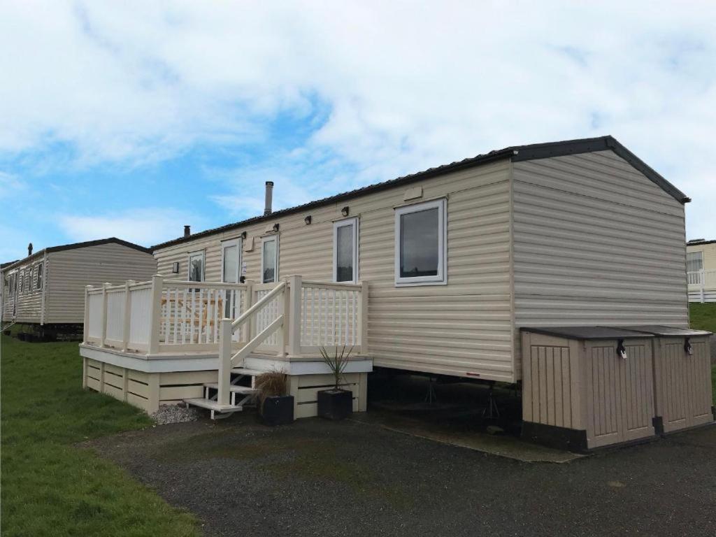 a mobile home with a porch and a deck at Newquay Bay Porth Caravan - 8 Berth in Newquay