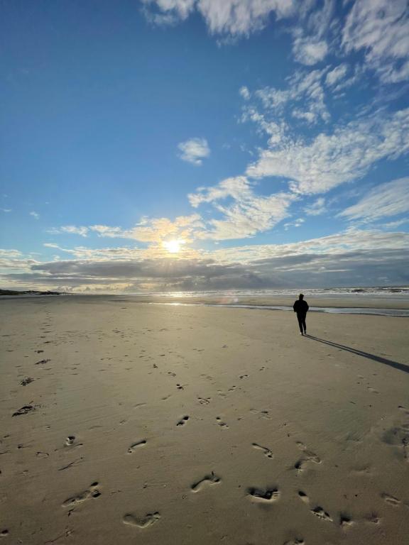 een persoon die op een strand loopt met voetafdrukken in het zand bij Effe Niks in Buren